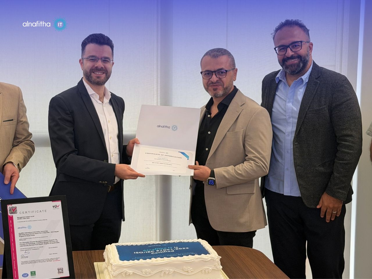 Alnafitha IT team members holding a certificate of appreciation after achieving ISO/IEC 27001:2022 certification